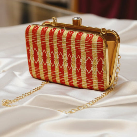 Red and gold traditional patterned clutch bag with a chain strap 